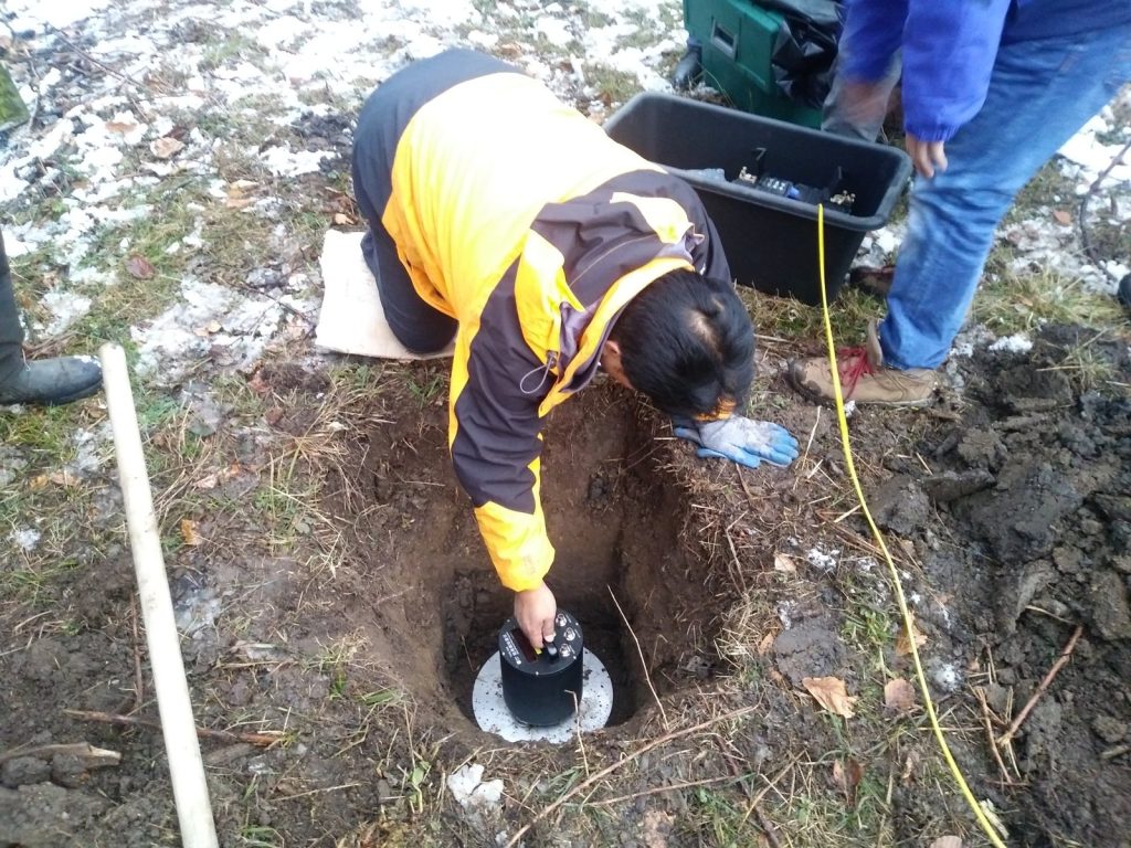 A seismometer is levelled in a test pit